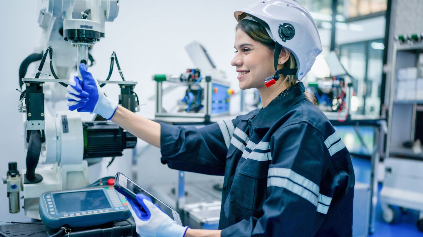 Bildet viser en kvinnelig ingeniør som jobber med robotteknologi.