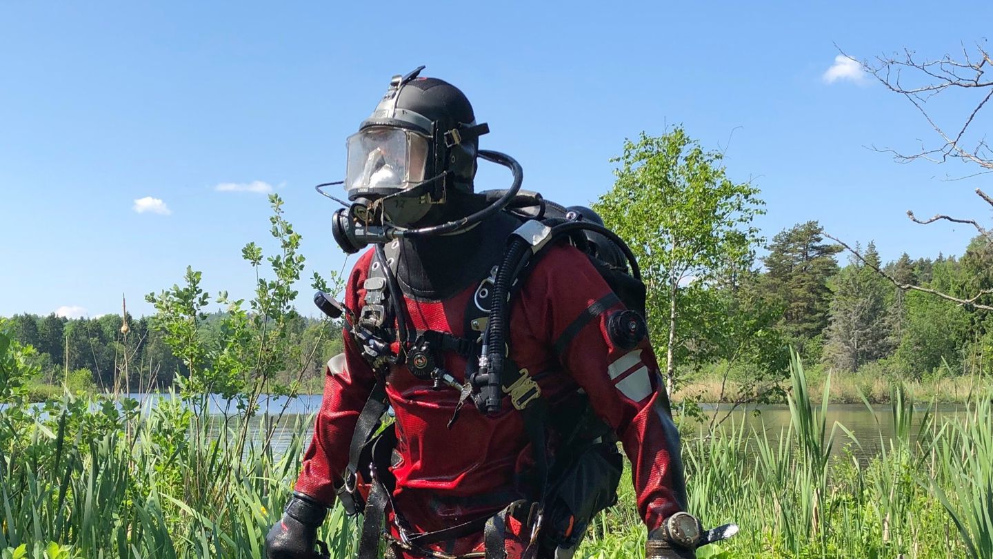 Dykker i fullt utstyr på veg opp av vannet